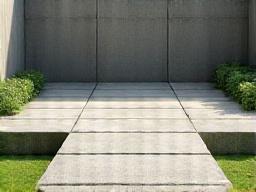 直線的なコンクリートの壁と延段で構成されたモダンな庭